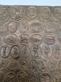 Bronze relief med romerske bordel mønter