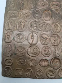 Bronze relief med romerske bordel mønter