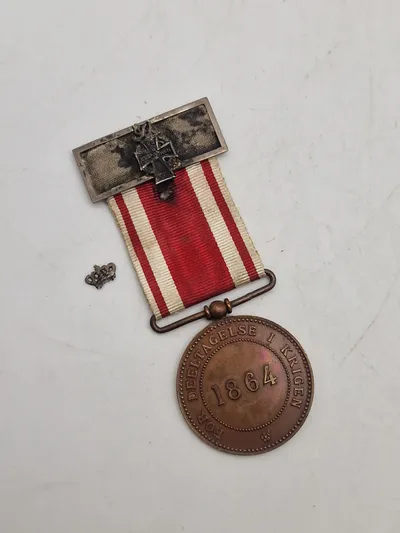 Original medalje for deltagelse i 2 Slesvigske krig 1864 - med miniature udgaven af dannebrogsmændenes hæderstegn påmonteret
