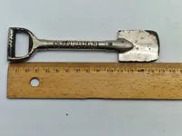 Miniature spade med teksten “Bellahøj” fra indvielsen