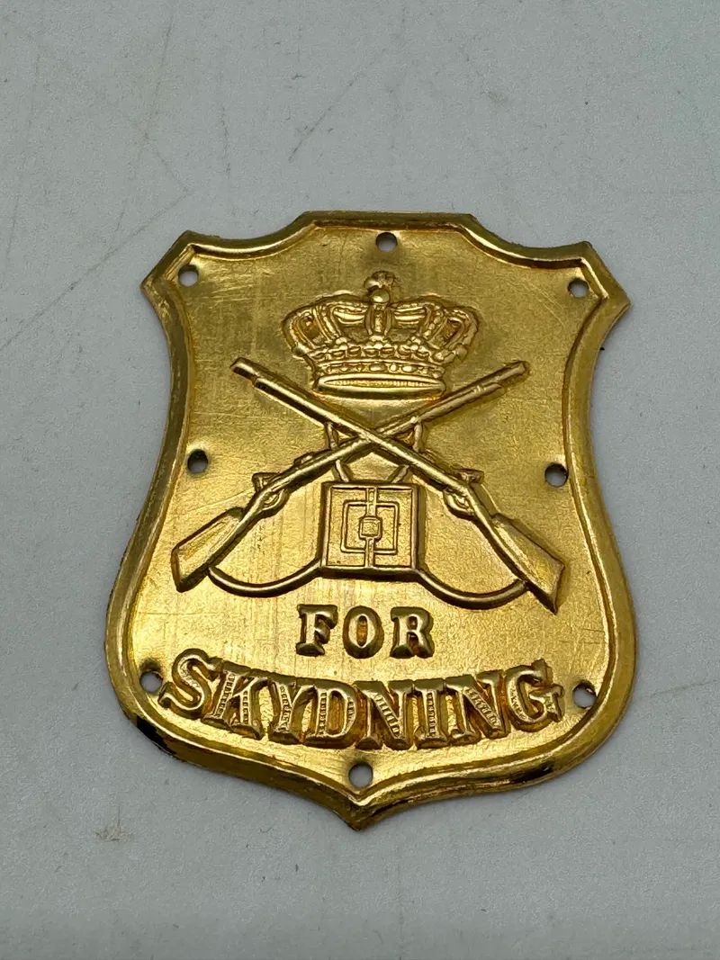 Ubrugt mint Dansk Skytteskjold 1903 anlagt på venstre overærme