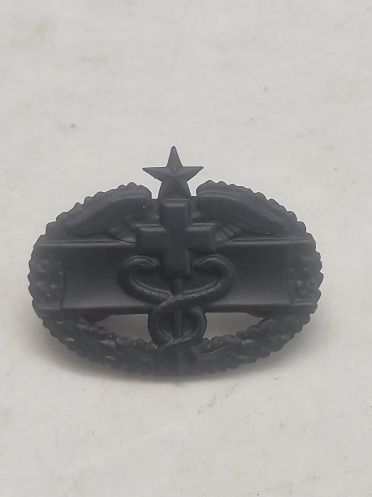 Originalt Combat Medical Badge (CMB) i sort mat finish, som er en militær udmærkelse fra den amerikanske hær.