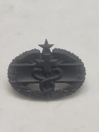 Originalt Combat Medical Badge (CMB) i sort mat finish, som er en militær udmærkelse fra den amerikanske hær.