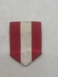 Medaljeæske med teksten i låget: Integritas: Redelighed - Fidelitas: Trofasthed - Virtus: Dygtighed + rødt/hvidt medaljebånd