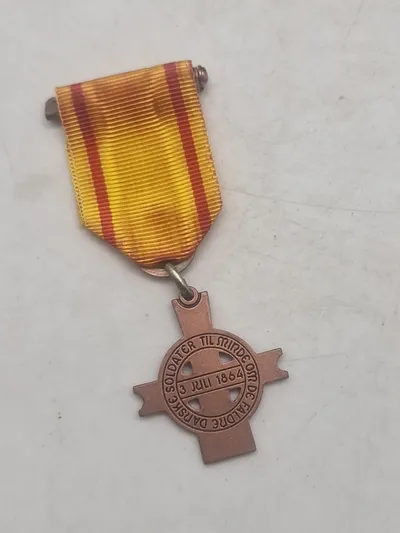 Mindemedalje med bånd: "Til minde om de faldne danske soldater 3. juli 1864"