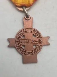 Mindemedalje med bånd: "Til minde om de faldne danske soldater 3. juli 1864"