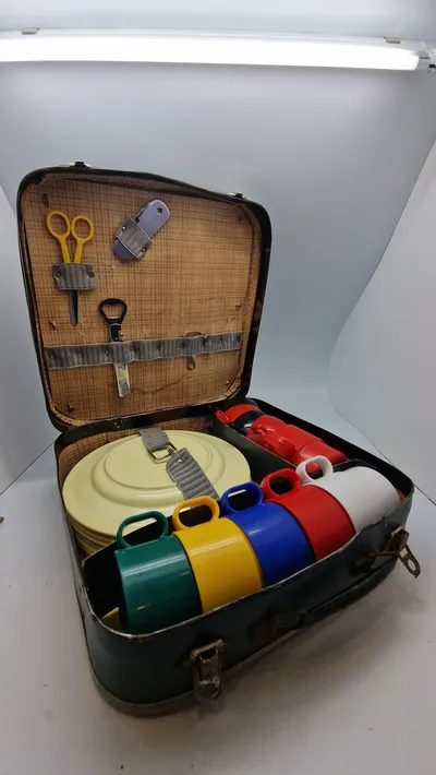 vintage picnickuffert, der indeholder service til flere personer.