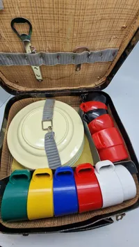 vintage picnickuffert, der indeholder service til flere personer.