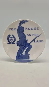 Original mindeplatte fra Royal Copenhagen fra 1898, designet af Arnold Krog. Den blev udgivet i anledning af 50-året for krigen i 1848
