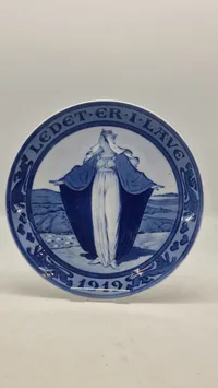 Original mindeplatte fra Royal Copenhagen fra 1919. Den blev designet af Oluf Jensen og kaldes også "Børnehjælpsdagsplatten"