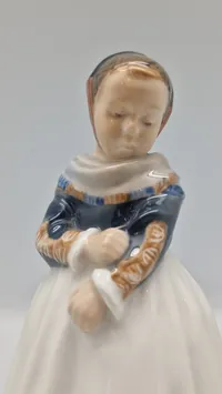 Original porcelænsfigur fra Royal Copenhagen, der forestiller en pige i amagerdragt, kendt som "Amagerpige"