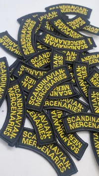 broderede navnemærker med teksten "SCANDINAVIAN MERCENARIES"
