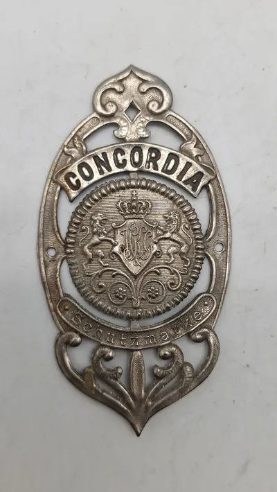 Originalt gammelt cykelhovedskilt ("Steuerkopfschild") med teksten "CONCORDIA Schutz Marke".
