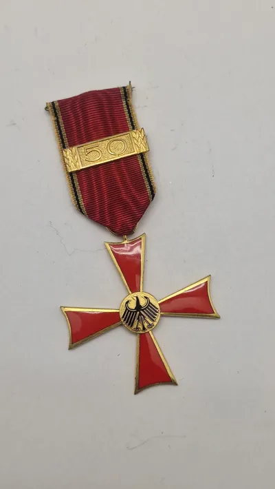 Bundesverdienstkreuz (Forbundsrepublikken Tysklands Fortjenstorden), specifikt en udgave med en 50-års nål for lang og tro tjeneste. Original
