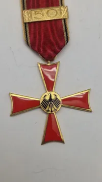 Bundesverdienstkreuz (Forbundsrepublikken Tysklands Fortjenstorden), specifikt en udgave med en 50-års nål for lang og tro tjeneste. Original