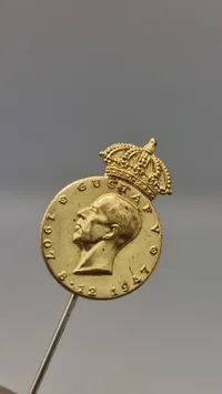 Pin fra Det Kongelige Patriotiske Samfund, der ærer Kong Gustaf V i anledning af hans 90-års fødselsdag i 1947. Original