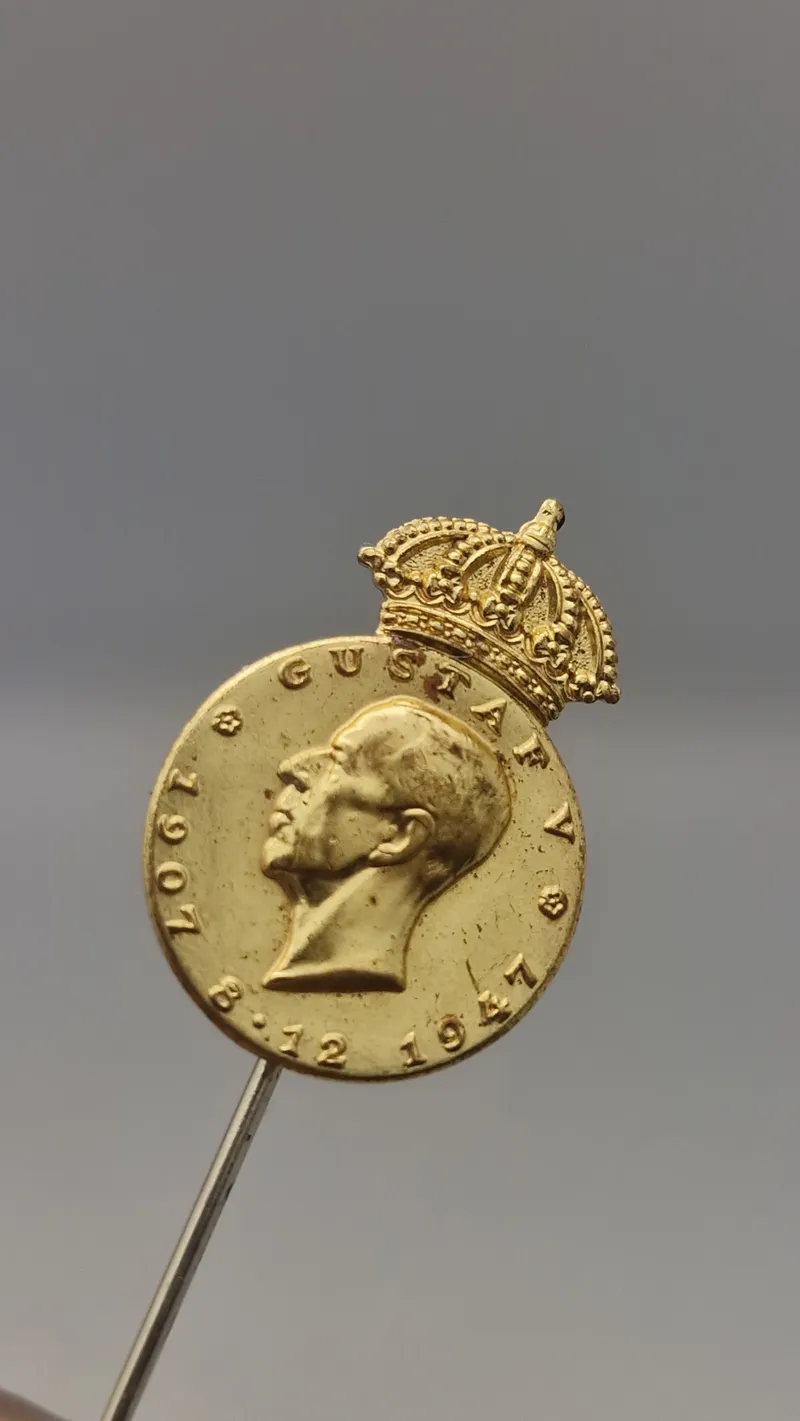 Pin fra Det Kongelige Patriotiske Samfund, der ærer Kong Gustaf V i anledning af hans 90-års fødselsdag i 1947. Original