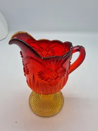 Glas opsats og kande fra Fyens Glasværk, opsatsen og kanden er i presset glas. Skålen, på opsatsen, er rød og stilken er gul, farverne fader ud fra rød til gul