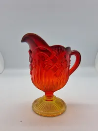 Glas opsats og kande fra Fyens Glasværk, opsatsen og kanden er i presset glas. Skålen, på opsatsen, er rød og stilken er gul, farverne fader ud fra rød til gul