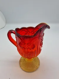 Glas opsats og kande fra Fyens Glasværk, opsatsen og kanden er i presset glas. Skålen, på opsatsen, er rød og stilken er gul, farverne fader ud fra rød til gul