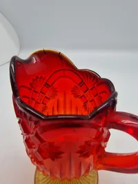 Glas opsats og kande fra Fyens Glasværk, opsatsen og kanden er i presset glas. Skålen, på opsatsen, er rød og stilken er gul, farverne fader ud fra rød til gul