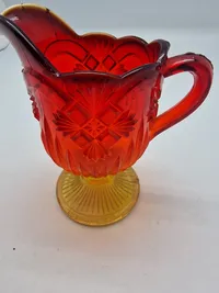 Glas opsats og kande fra Fyens Glasværk, opsatsen og kanden er i presset glas. Skålen, på opsatsen, er rød og stilken er gul, farverne fader ud fra rød til gul