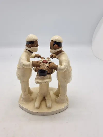 Sjælden Skulptur som forestiller to læger, der udfører en operation, og er skabt af den brasilianske folkekunstner Amaro Rodrigues