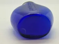 Blå spytflaske af glas med metalkapsel og gradueret skala i kubikcentimeter, som blev brugt til at opsamle spyt fra patienter med tuberkulose, især i perioden 1871-1920