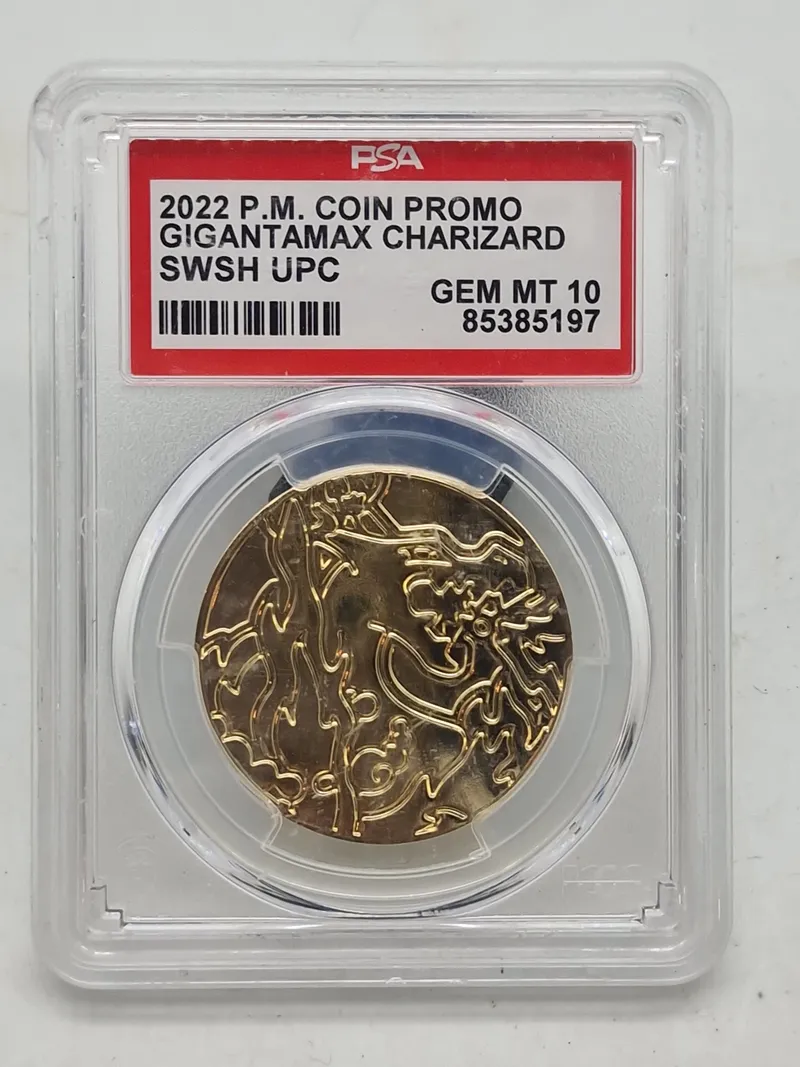 2022 P.M. Coin Promo Gigantamax Charizard mønt fra Pokémon Trading Card Game. Denne guldfarvede mønt blev udgivet som en del af en promo-udgivelse i 2022 og viser Charizard i sin Gigantamax-form.