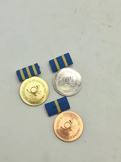 Für treue Dienste bei der Deutschen Post" (For tro tjeneste i Deutsche Post), som blev uddelt i Den Tyske Demokratiske Republik (DDR) fra 1960. 1-2-3