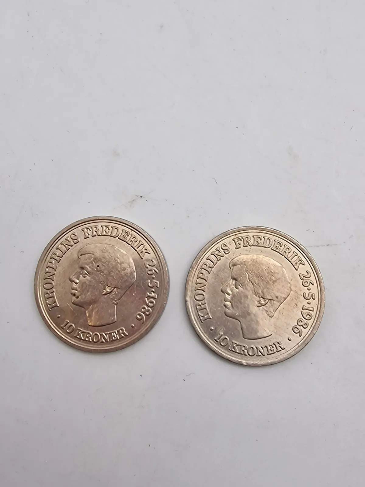 Originale dansk e10-kronemønter udgivet i anledning af Kronprins Frederik X's 18-års fødselsdag den 26. maj 1986.