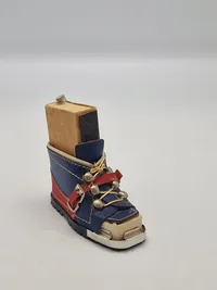 miniature af en skistøvle, der fungerer som en holder til en æske tændstikker og en lille ishakke.