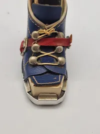 miniature af en skistøvle, der fungerer som en holder til en æske tændstikker og en lille ishakke.