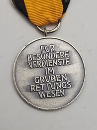 Grubenwehr-Ehrenzeichen. Dette er en statslig udmærkelse, der tildeles for særlige personlige fortjenester inden for mineredningsvæsenet.