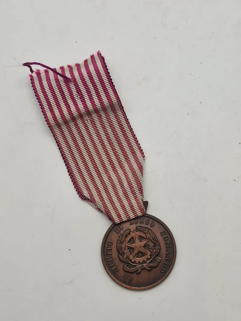 Original "Medaglia al Merito di Servizio" (Tjenestefortjenstmedalje) eller "Croce per Anzianità di Servizio" (Kors for Anciennitet i Tjeneste)