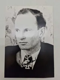 Billede af  Felix Zymalkowski, en tysk ubådskommandant under Anden Verdenskrig. Han er iført uniform og bærer Jernkorsets Ridderkors med Egeløv - original signatur