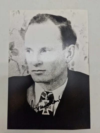 Billede af  Felix Zymalkowski, en tysk ubådskommandant under Anden Verdenskrig. Han er iført uniform og bærer Jernkorsets Ridderkors med Egeløv - original signatur
