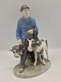 Royal Copenhagen figur kaldet "Dreng med Kalve" eller "Bondedreng m/ kalve", med nummer 1858. Figuren er designet af Christian Thomsen.