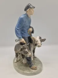 Royal Copenhagen figur kaldet "Dreng med Kalve" eller "Bondedreng m/ kalve", med nummer 1858. Figuren er designet af Christian Thomsen.