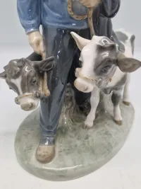 Royal Copenhagen figur kaldet "Dreng med Kalve" eller "Bondedreng m/ kalve", med nummer 1858. Figuren er designet af Christian Thomsen.