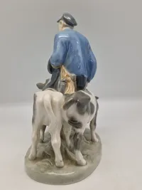 Royal Copenhagen figur kaldet "Dreng med Kalve" eller "Bondedreng m/ kalve", med nummer 1858. Figuren er designet af Christian Thomsen.