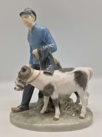 Royal Copenhagen figur kaldet "Dreng med Kalve" eller "Bondedreng m/ kalve", med nummer 1858. Figuren er designet af Christian Thomsen.