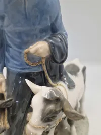 Royal Copenhagen figur kaldet "Dreng med Kalve" eller "Bondedreng m/ kalve", med nummer 1858. Figuren er designet af Christian Thomsen.