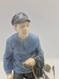 Royal Copenhagen figur kaldet "Dreng med Kalve" eller "Bondedreng m/ kalve", med nummer 1858. Figuren er designet af Christian Thomsen.