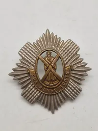 Originalt WW1/WW2 kasketmærke fra The Royal Scots (The Royal Regiment), et historisk infanteriregiment i den britiske hær