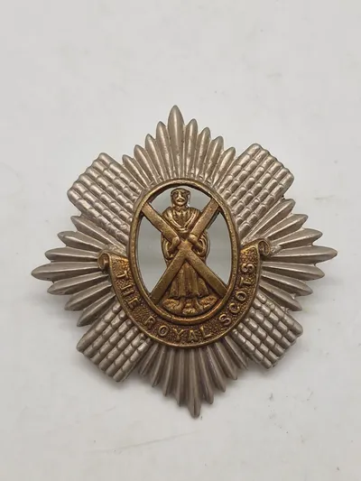 Originalt WW1/WW2 kasketmærke fra The Royal Scots (The Royal Regiment), et historisk infanteriregiment i den britiske hær