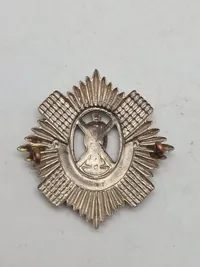 Originalt WW1/WW2 kasketmærke fra The Royal Scots (The Royal Regiment), et historisk infanteriregiment i den britiske hær