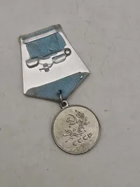 Original sovjetisk medalje kendt som "Medal for Saving the Drowning" (Медаль «За спасение утопающих»).