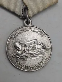 Original sovjetisk medalje kendt som "Medal for Saving the Drowning" (Медаль «За спасение утопающих»).