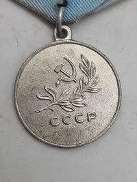 Original sovjetisk medalje kendt som "Medal for Saving the Drowning" (Медаль «За спасение утопающих»).